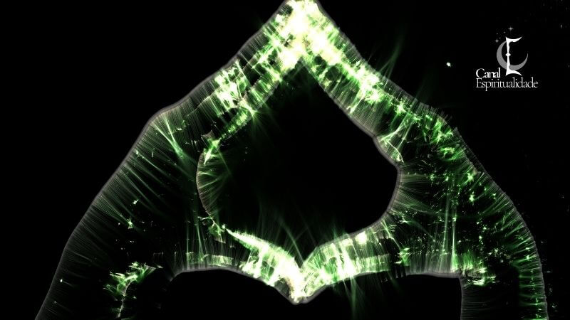 Fotografia Kirlian - técnica identifica estresse Imagem abstrata de duas mãos unidas formando um triângulo ou losango. A silhueta das mãos é delineada por uma luz verde brilhante e intensa, com inúmeros filamentos e faíscas que se estendem para fora, criando uma rede de energia verde neon contra o fundo escuro.